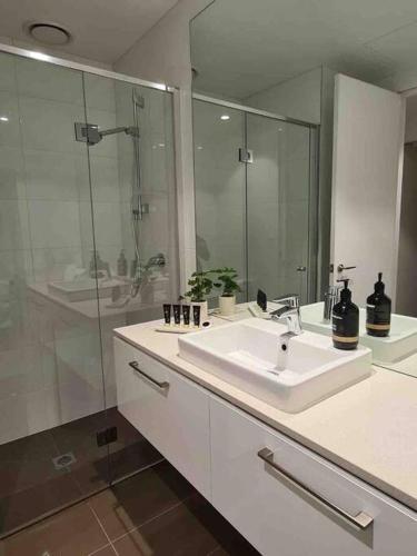 a white bathroom with a sink and a shower at Lux 3 Bedroom Apartment in Southbank in Melbourne