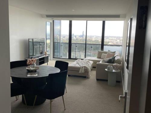a living room with a table and a couch at Lux 3 Bedroom Apartment in Southbank in Melbourne