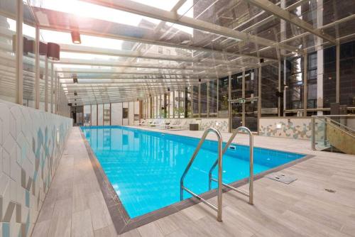 a large swimming pool with blue water in a building at Lux 3 Bedroom 2 Bathroom Apt Southbank in Melbourne