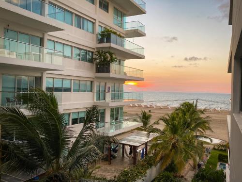 an apartment building overlooking the beach at sunset at Apartamento en Cartagena con vista al mar in Cartagena de Indias