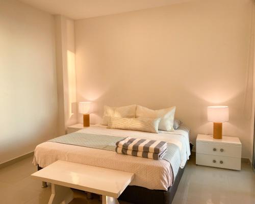 1 dormitorio con 1 cama con 2 lámparas y 1 mesa en Apartamento en Cartagena con vista al mar en Cartagena de Indias