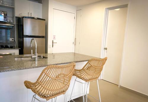 a kitchen with two wicker chairs at a counter at Vista al mar en Cartagena , Apartamento en Morros in Cartagena de Indias