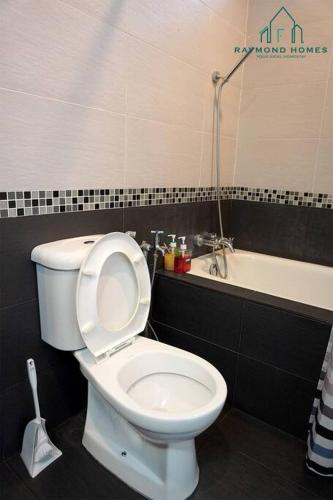 a bathroom with a white toilet and a bath tub at 99 Kelawei in George Town