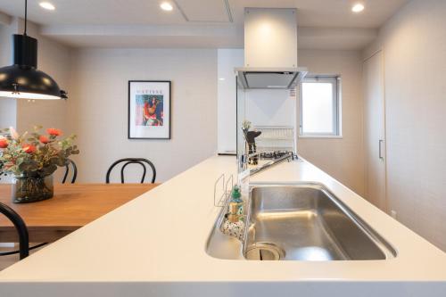 a kitchen with a sink and a counter top at Ken's Place麻布East in Tokyo