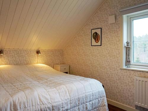 a bedroom with a white bed and a window at Holiday home Grebbestad IX in Grebbestad