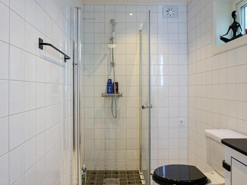 a bathroom with a shower with a black toilet at Holiday home Grebbestad IX in Grebbestad