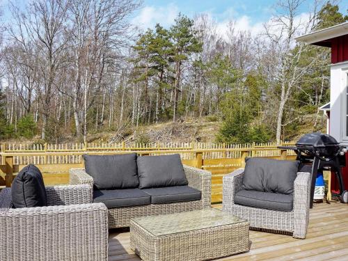 a patio with wicker furniture on a wooden deck at 8 person holiday home in Grebbestad-By Traum in Grebbestad