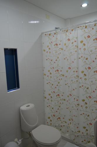 a bathroom with a shower curtain with a toilet at Hotel Primavera Santa Fe in Santa Fe de Antioquia