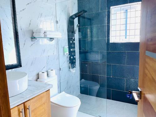 a bathroom with a toilet and a glass shower at Gaia Residence Deluxe in San Felipe de Puerto Plata