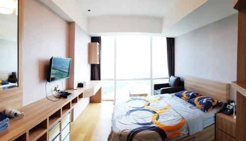 une chambre d'hôtel avec un lit et une télévision dans l'établissement U Residence Tower2 Supermal by Lippo Karawaci, à Klapadua