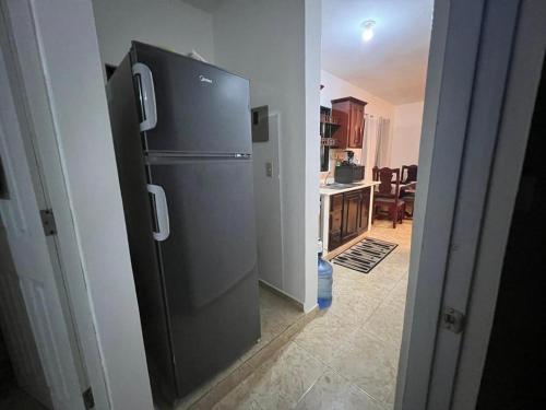 a kitchen with a black refrigerator in a room at Orimar in San Felipe de Puerto Plata