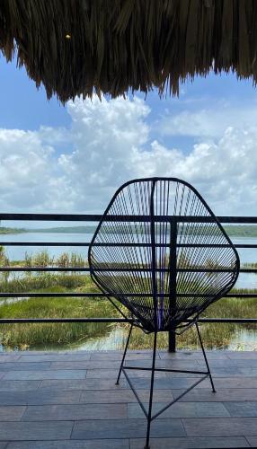 a bench sitting under a straw umbrella on a patio at Hotel Maya Internacional in Flores