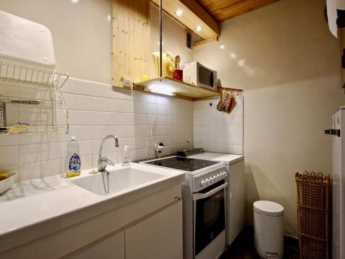 a small kitchen with a sink and a stove at Appartement Chamrousse, 2 pièces, 6 personnes - FR-1-549-49 in Chamrousse