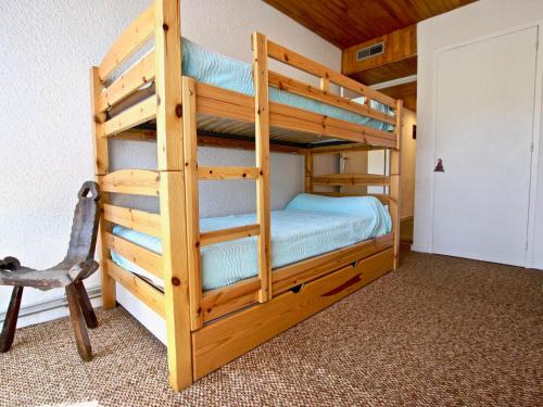 a bunk bed in a room with a chair at Appartement Chamrousse, 2 pièces, 6 personnes - FR-1-549-49 in Chamrousse