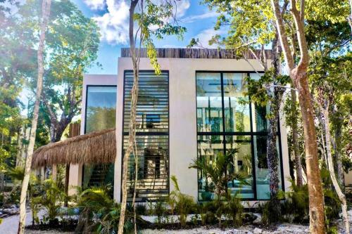 a house with a staircase in front of it at Villa Xuncari en el corazón de la selva Tulum in Tulum