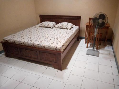 - une chambre avec un lit et un ventilateur dans l'établissement Kos Putri BANDARA Syariah- Kos Harian, Mingguan, Bulanan, à Wendit