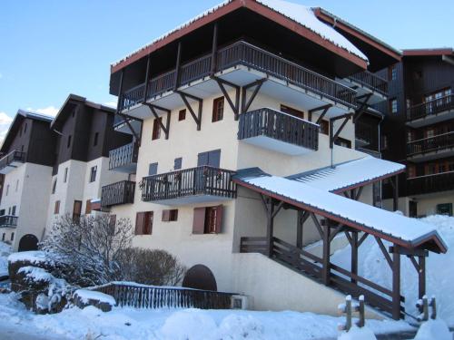 un bâtiment avec de la neige sur le sol devant lui dans l'établissement Studio chaleureux au centre, proche des pistes avec balcon - FR-1-181-2510, à La Plagne Tarentaise
