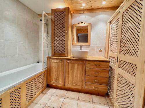 une salle de bain avec un lavabo et une baignoire dans l'établissement Spacieux appartement 8 personnes au pied des pistes avec parking et WiFi - FR-1-505-179, à Notre-Dame-de-Bellecombe