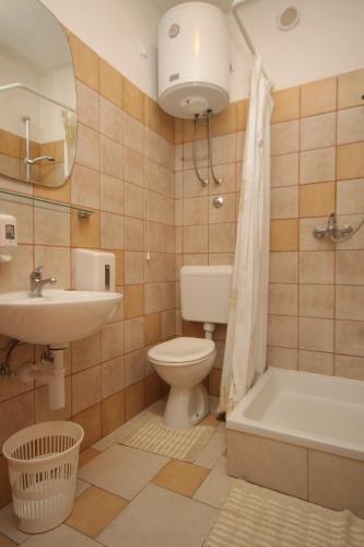 a bathroom with a toilet and a sink and a tub at Apartments by the sea Milna, Hvar - 8795 in Hvar