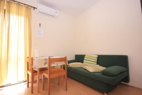 uma sala de estar com um sofá verde e uma mesa em Apartments by the sea Soline, Dubrovnik - 8825 em Mlini
