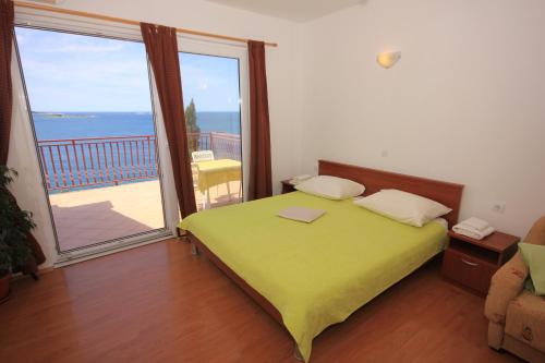 um quarto com uma cama verde e uma varanda em Apartments by the sea Soline, Dubrovnik - 8825 em Mlini