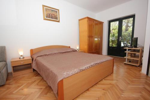 a bedroom with a bed and a television in it at Apartments by the sea Cavtat, Dubrovnik - 8826 in Cavtat
