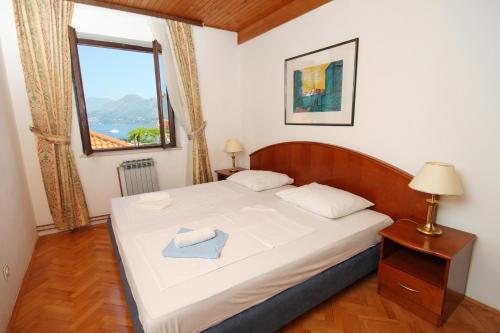 a small bedroom with a bed with a window at Apartments with a parking space Cavtat, Dubrovnik - 8986 in Mlini
