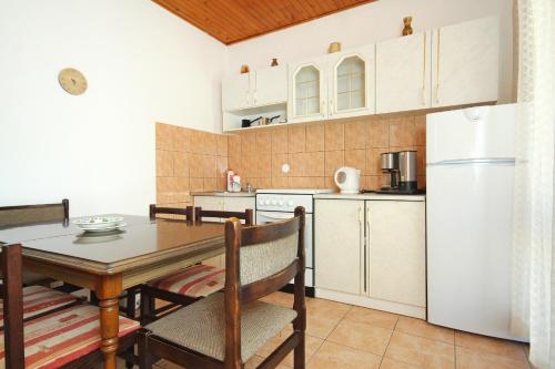 a kitchen and dining room with a table and a refrigerator at Apartments with a parking space Cavtat, Dubrovnik - 8986 in Mlini