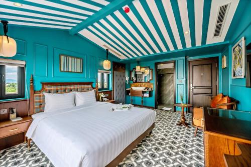 a bedroom with a large white bed and blue walls at Son Hoi An Boutique Hotel & Spa in Hoi An