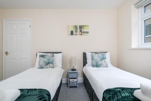 two beds sitting next to each other in a room at Redhill Surrey 2 Bedroom Pet Friendly Apartment by Sublime Stays in Redhill