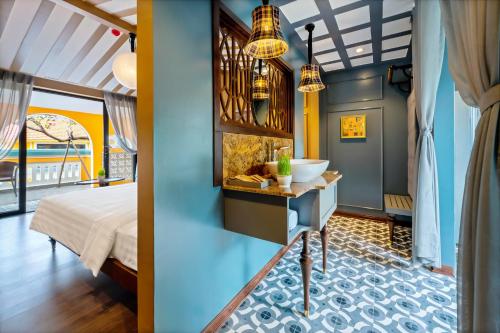 a bathroom with a sink and a bed in a room at Son Hoi An Boutique Hotel & Spa in Hoi An