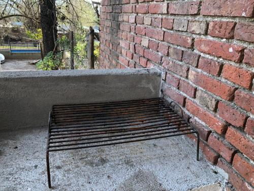 a metal bench sitting next to a brick wall at Casa Calo Bialet Massé in Bialet Massé