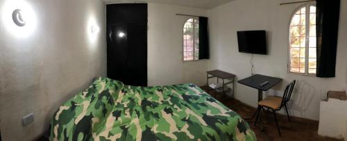 a bedroom with a bed with a camouflage blanket at Casa Calo Bialet Massé in Bialet Massé