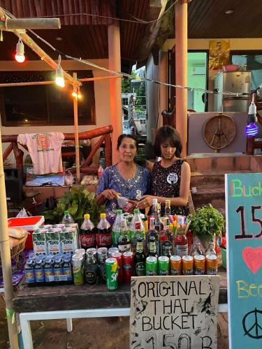 two women standing in front of a table with drinks at Boy Scouts Homestay in Ban Nua