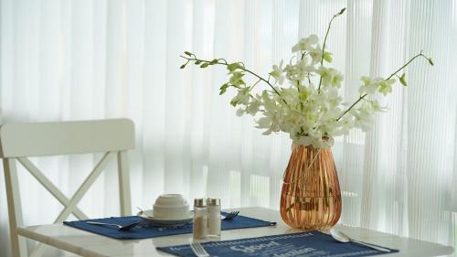 a vase with white flowers sitting on a table at BCP Hotel in Ban Chang