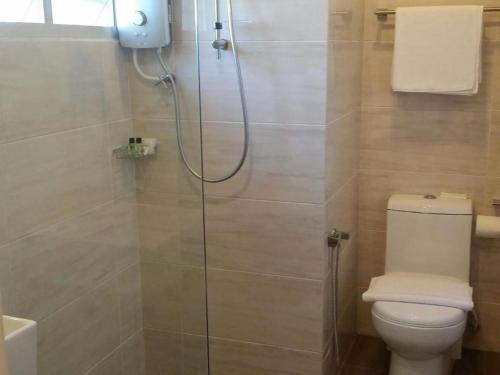 a bathroom with a glass shower with a toilet at Riverside Boutique Hotel in Kuantan