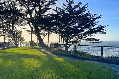 a park with trees and a fence and the ocean at Entire Private Coastal Retreat - Spectacular Ocean Views wHot Tub in Montara