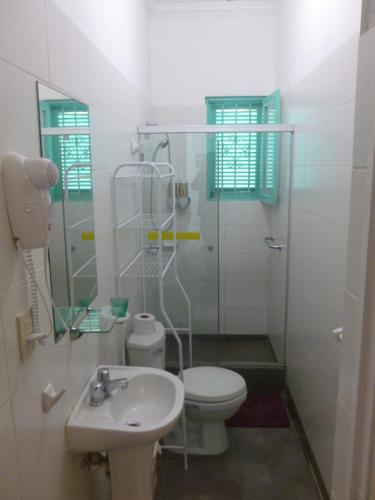 a white bathroom with a toilet and a sink at La Casona Azul in Lima
