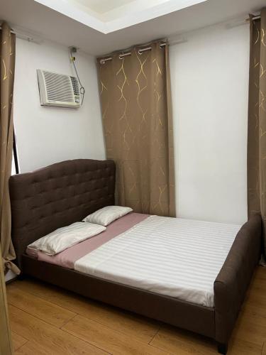 a bed in a room with a air conditioner at Davao Transient Villa with 24hrs security guard BBQ Grill , Free Parking and Wifi in Davao City