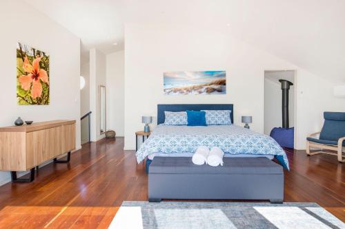a bedroom with a king sized bed with blue accents at Eclipse Absolute Beachfront with Stunning Views in Culburra Beach