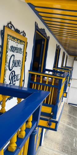 a group of blue and yellow benches in a building at Hospedaje Camino Real a 150 MTS del centro in Salento