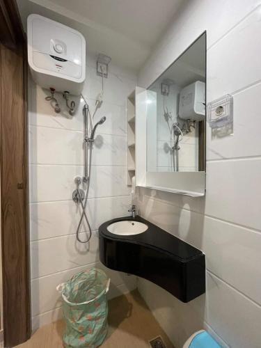 a bathroom with a sink and a mirror at Precious Angel Apartment Sky House BSD in Pagedangan