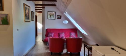 a living room with a red couch and two red stools at The parrot hotel, live in a rescue animal park in Næstved