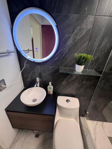 a bathroom with a white toilet and a mirror at Comfortable apartment with parking, best location in Guadalajara