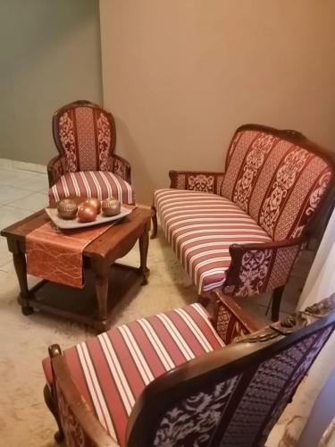 a living room with two chairs and a coffee table at The Signature Guesthouse in Roodepoort