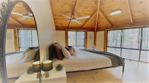 - une chambre avec un grand lit et un ventilateur de plafond dans l'établissement Unlax @ Hunter Valley, à Pokolbin