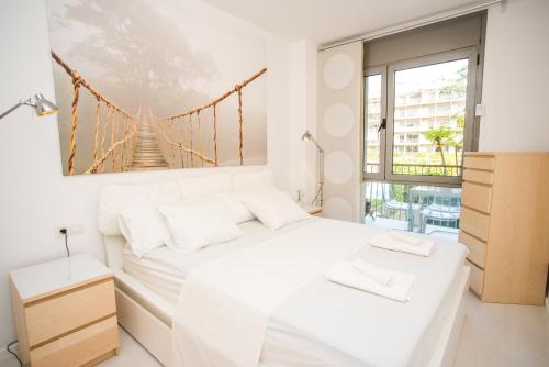 a white bedroom with a bridge painting on the wall at Opening Doors Pueblonuevo in Barcelona