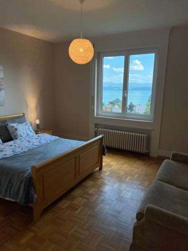 a bedroom with a bed and two large windows at Alpes 54 in Neuchâtel