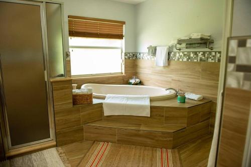 La salle de bains est pourvue d'une baignoire et d'une fenêtre. dans l'établissement Charming vacation home in Port St Lucie., à Port Sainte-Lucie