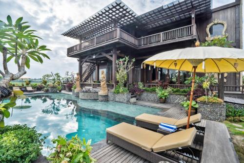 uma villa com uma piscina e uma casa em Royal Roco Villa em Tanah Lot